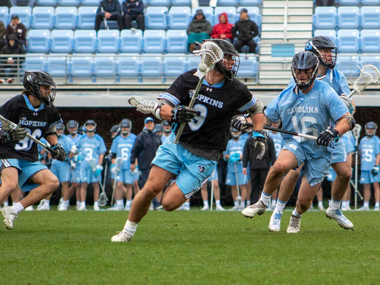 5th year defenseman Sean Morris (16) keeps pace with the other team in the Feb. 27 men's lacrosse game against Johns Hopkins University. UNC won 15-9.