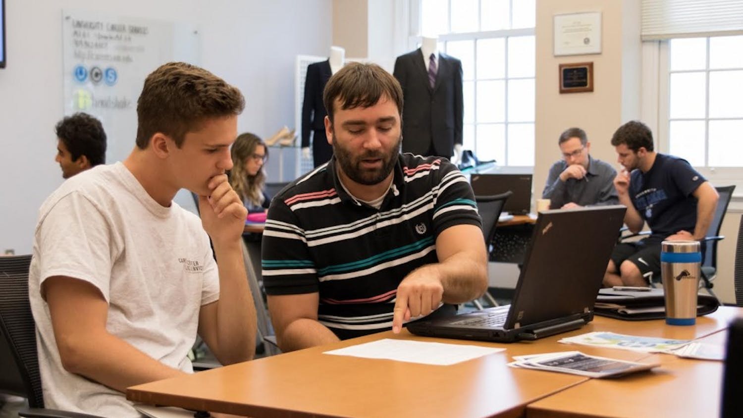 UNC student Trey Sullivan (left) and Assistant Director of Career Services, Jonathan Adams (right), participate in a business school workshop in Hanes Hall on Aug. 28, 2017.