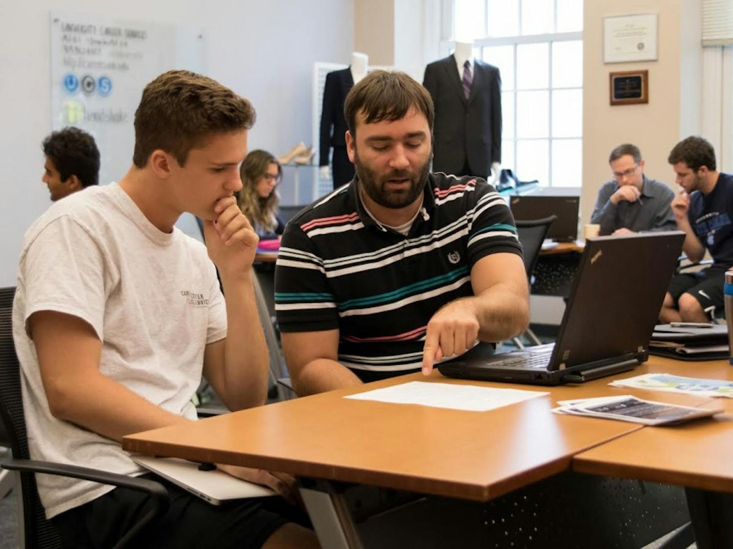 UNC student Trey Sullivan (left) and Assistant Director of Career Services, Jonathan Adams (right), participate in a business school workshop in Hanes Hall on Aug. 28, 2017.