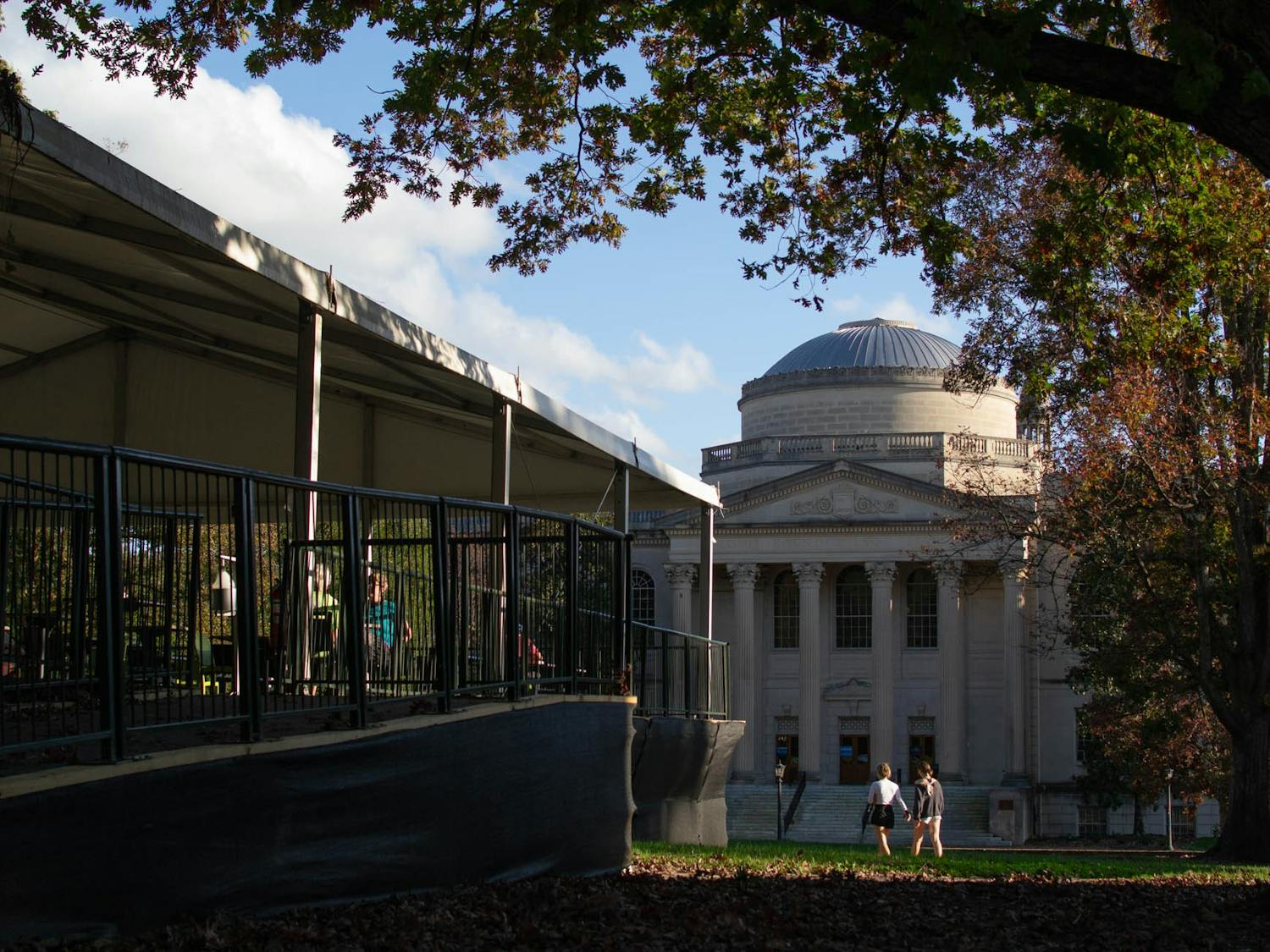 Students study at the outdoor and socially-distanced study area the University built on Polk Place as other students walk past Wilson Library on Sunday, Nov. 15, 2020.