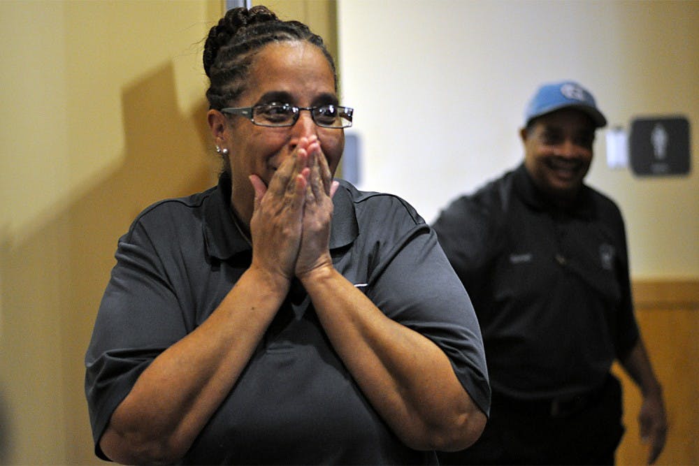 Carolina Dining Services employee Deborah Paige reacts to a presentation of $5,000 from students Sarah Adams and Caitlin Ball on Wednesday.