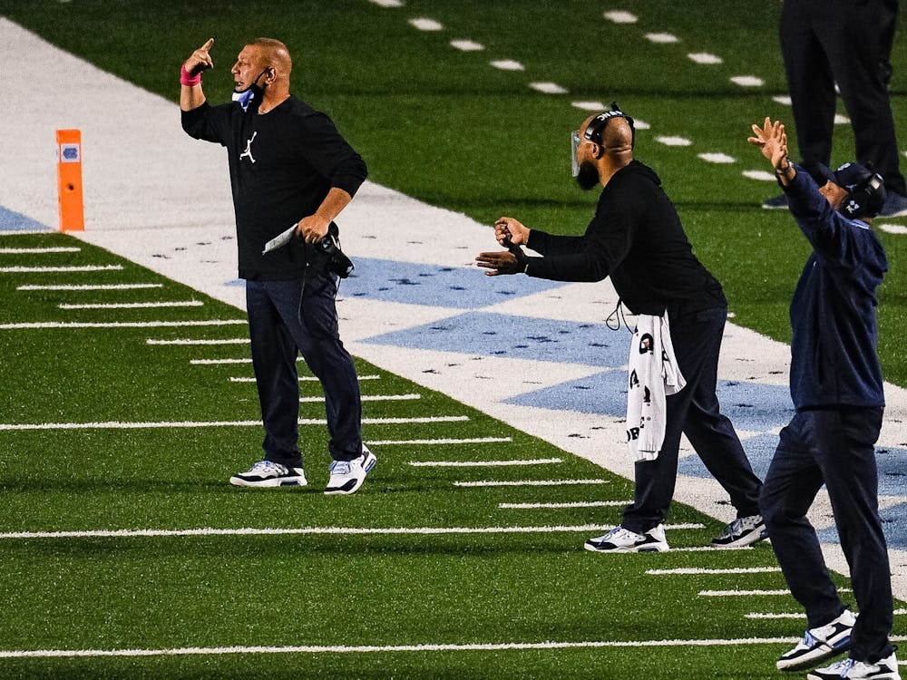 UNC offensive coordinator and quarterbacks coach Phil Longo yells instructions alongside other coaches during a game against Notre Dame in Kenan Memorial Stadium on Friday, Nov. 27, 2020. Notre Dame beat UNC 32-17.