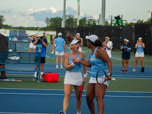 Junior Fiona Crawley (left) and graduate student Abbey Forbes celebrate after winning a game against N.C. State on May 20, 2023. The Tar Heels went on to win the match, 4-1.