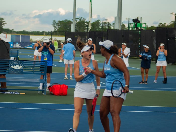 Junior Fiona Crawley (left) and graduate student Abbey Forbes celebrate after winning a game against N.C. State on May 20, 2023. The Tar Heels went on to win the match, 4-1.