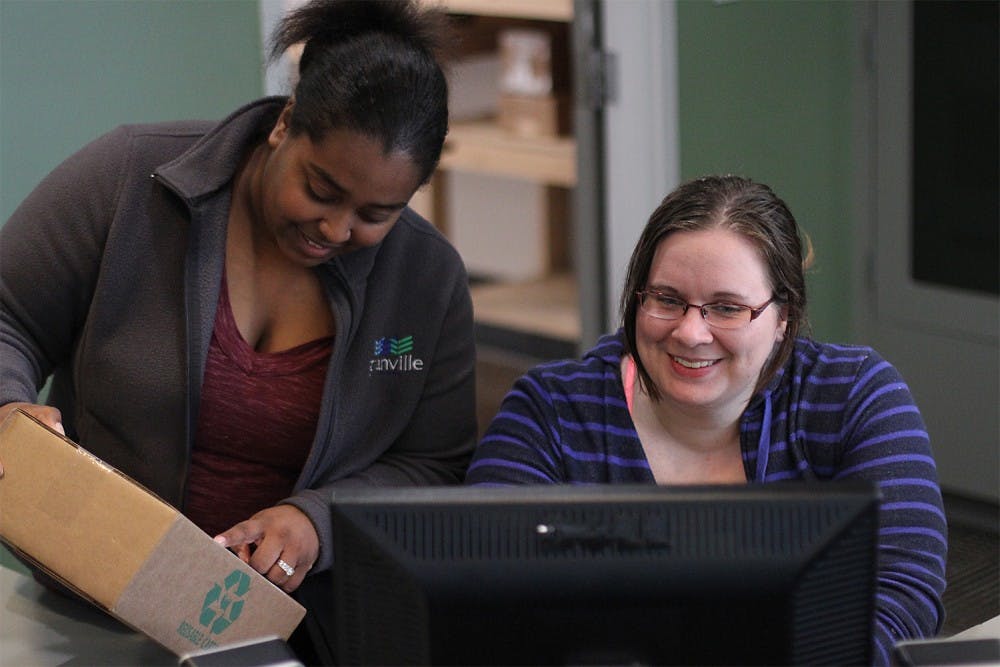 Shavon Flowers (left) and Meghan Eisenhardt, a sophomore undecided major from Greensboro, work at Granville Towers. Both have worked there since September 2013, Eisenhardt as a desk attendant and Flowers as a receptionist.