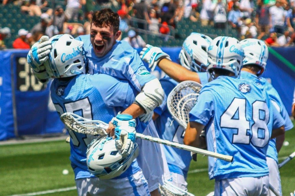 UNC attacker&nbsp;Brian Cannon (11) embraces his teammate, defenseman Joe Kenna (37), after the North Carolina men's lacrosse team defeated Loyola Maryland 18-13 in the NCAA semifinals at Lincoln Financial Field in Philadelphia on Saturday.