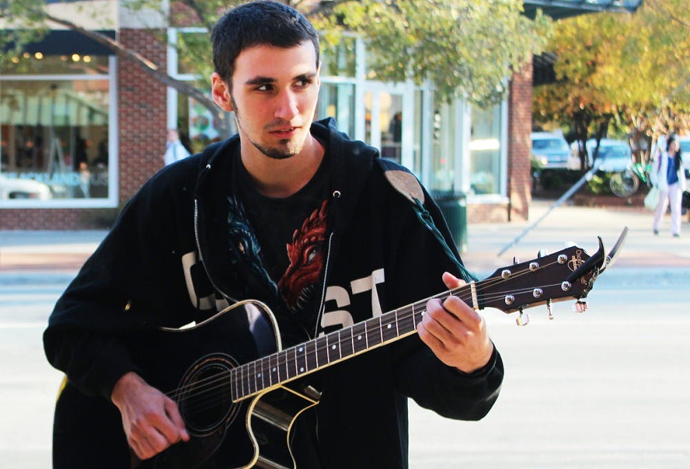 	Shawn Radcliffe plays the guitar on Franklin Street on Moday.  He was playing to raise money to buy a copy of Halo 4. 