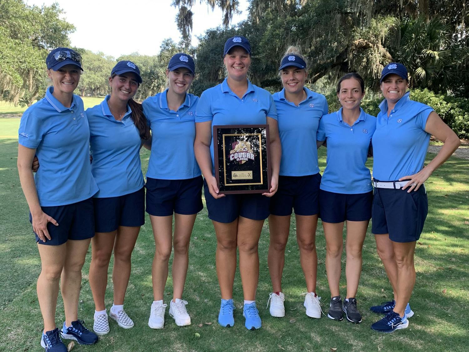The UNC women's golf team poses around Krista Junkkari's second-place trophy after the Cougar Classic in Charleston, SC, on Sept. 14. Photo Courtesy of UNC Athletic Communications. 