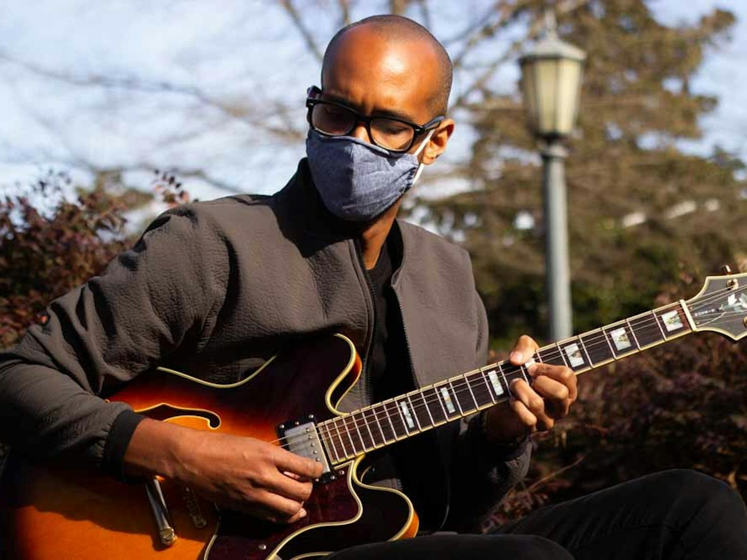 Musician Keenan Jenkins, or XOXOK, plays guitar at the Old Well on Friday, March 5th, 2021.