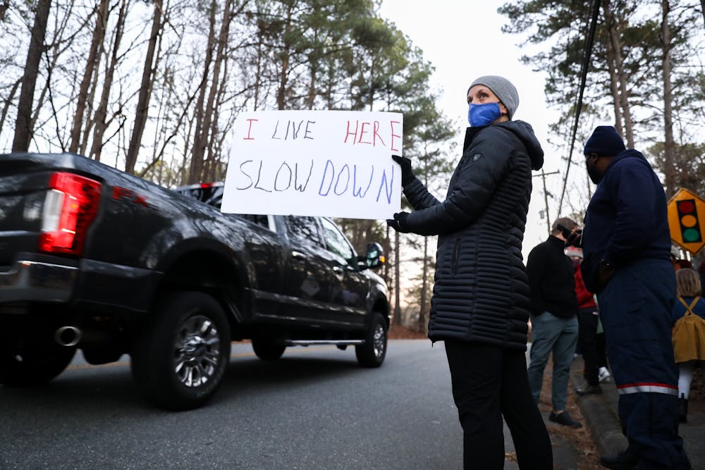 Chapel Hill resident Megan Foureman holds a sign asking drivers to slow down during a protest on Estes Drive on Friday, Jan. 7, 2022.