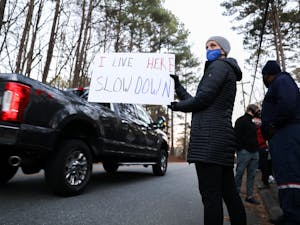 Chapel Hill resident Megan Foureman holds a sign asking drivers to slow down during a protest on Estes Drive on Friday, Jan. 7, 2022.