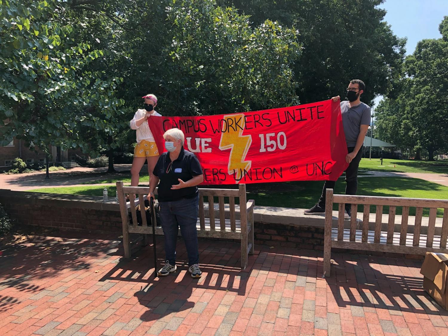UNC community members hold a sign advocating for UE Local 150, the North Carolina Public Service Workers Union, at their protest on Thursday, Aug. 27, 2020.