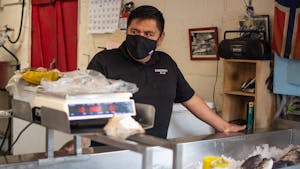 Salvador Bonilla is the current owner of Tom Robinson's Seafood, which was passed down to him by Kay Hamrick, Tom Robinson's girlfriend of 17 years, after Robinson's death in 2010. He is pictured standing at the seafood counter on Saturday, April 1, 2023.