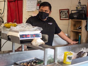 Salvador Bonilla is the current owner of Tom Robinson's Seafood, which was passed down to him by Kay Hamrick, Tom Robinson's girlfriend of 17 years, after Robinson's death in 2010. He is pictured standing at the seafood counter on Saturday, April 1, 2023.