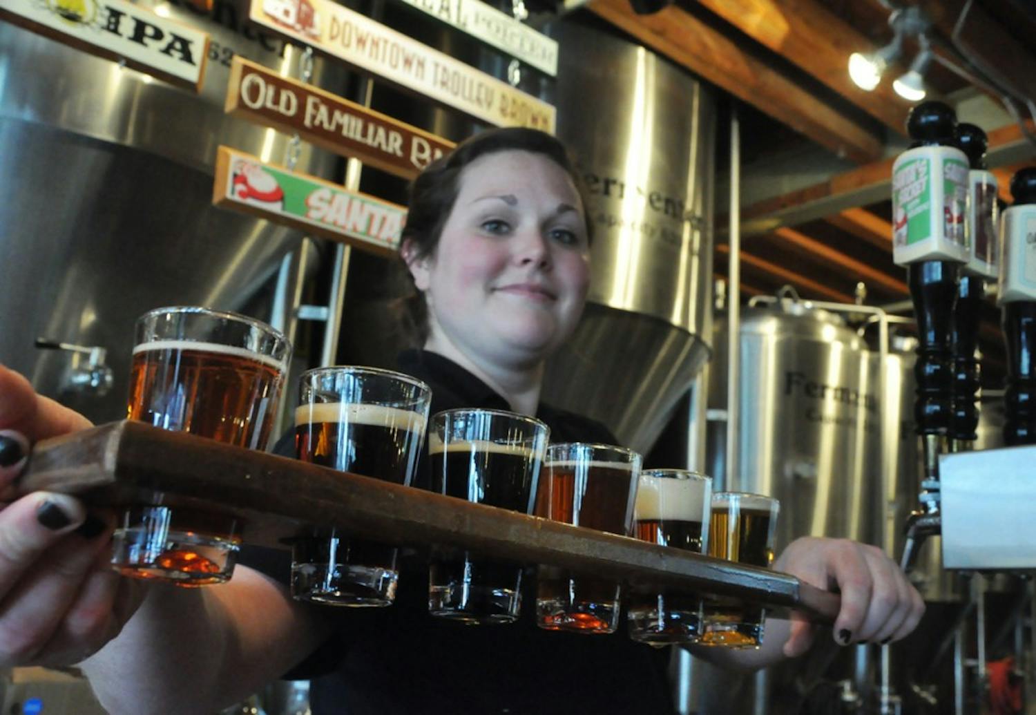 Leanna Tyndall, 23, holds Carolina Brewery’s sampler paddle on Thursday.  The Chapel Hill native has worked at the bar and restaurant on and off for the past six years.  The brewery has recently expanded their beer distribution to more areas across North Carolina.  