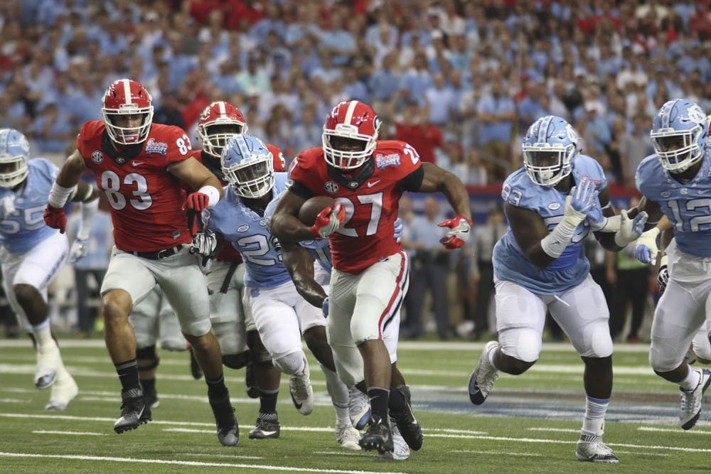Georgia running back Nick Chubb (27) breaks through UNC's defensive line on his way to rushing for 222 yards.