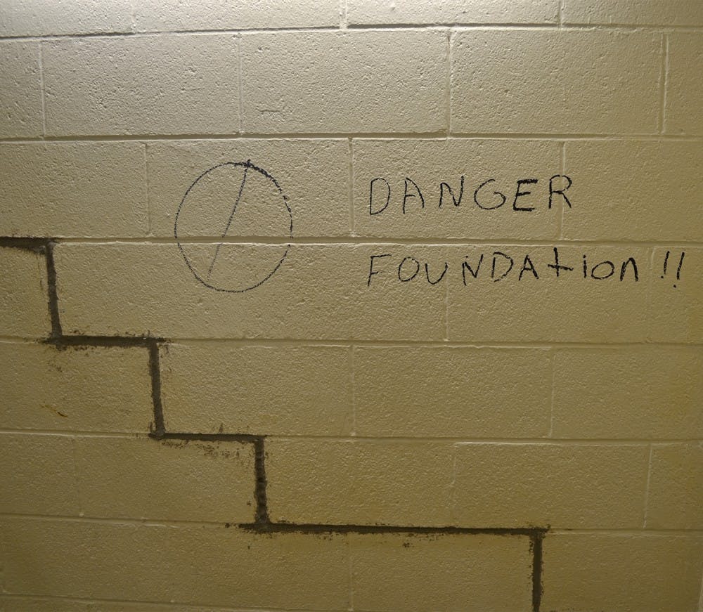 In the ground floor of a Hamilton stairwell, a strange "Danger!" sign is written next to cracks in the foundation.