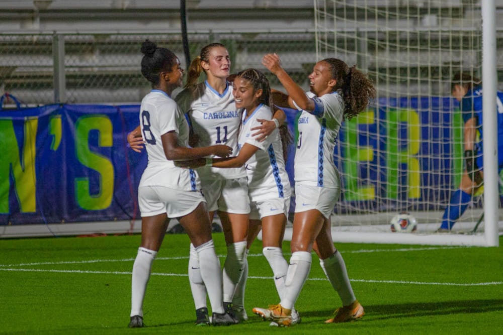 <p>Members of UNC's women's soccer team celebrate their first goal, scored by junior midfielder Brianna Pinto (8), during the first round of the ACC tournament against Virginia Tech on Tuesday, Nov. 10, 2020 at WakeMed Soccer Park. UNC beat Virginia Tech 1-0, with Pinto's goal being the only of the night.&nbsp;</p>