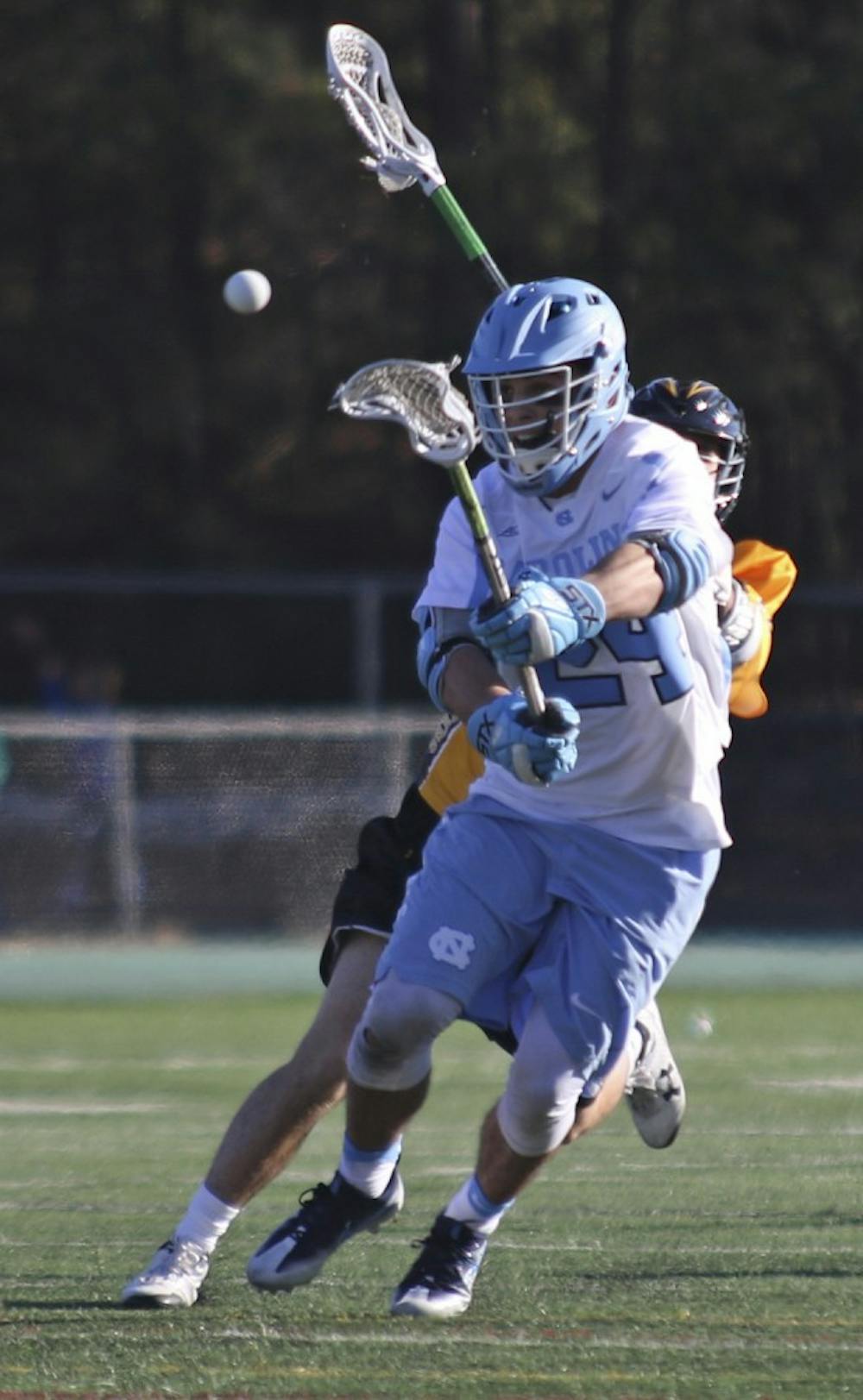 <p>UNC midfielder Stephen Kelly (24) fires a shot after winning a face-off against UMBC on Saturday at Cardinal Gibbons High School in Raleigh.</p>