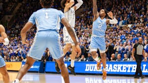 UNC junior guard Caleb Love (2) defends Duke first-year guard Tyrese Proctor (5) during the men's basketball game against Duke on Feb. 4, 2023, at Cameron Indoor Stadium.