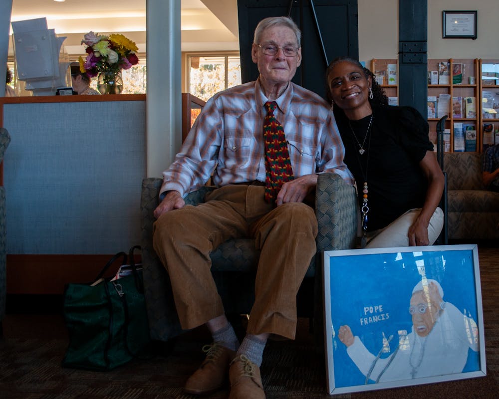 Artist Gary Owens photographed with Cydnee Sims on Friday, Oct. 7, 2022 at the Robert and Pearl Seymour Center with one of Owens' caricature paintings. Sims is the programs and operations manager of the Seymour Center.