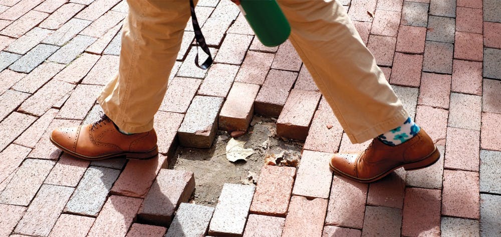 <p>D’Angelo Gatewood, a chemistry and public relations double major, crosses a patch of missing bricks on his way to an Admissions Ambassadors interview.</p>