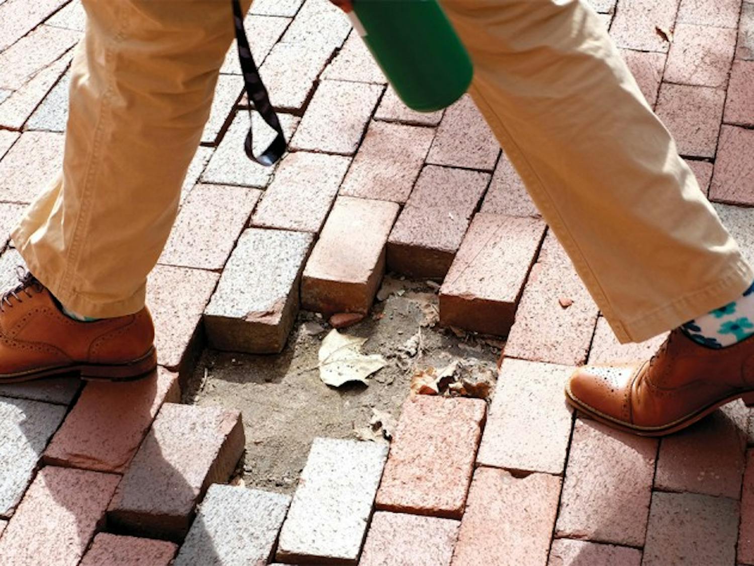 D’Angelo Gatewood, a chemistry and public relations double major, crosses a patch of missing bricks on his way to an Admissions Ambassadors interview.