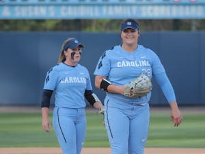 Senior Taylor Wike (7) and sophomore Brittany Pickett (28) joke during a game against N.C. State on April 13 at Anderson Stadium.