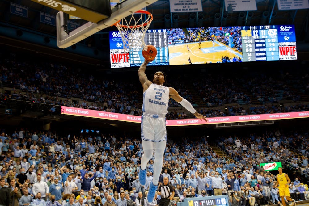 Sophomore guard Caleb Love (2) goes up for a dunk on a quick break during UNC basketball's home game against Michigan on Wednesday, Dec. 1, 2021.