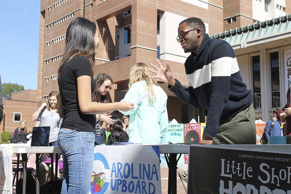 Roderick Gladney (right) helps recruit new members during Carolina Cupboard's opening week of events in the Pit on Monday .