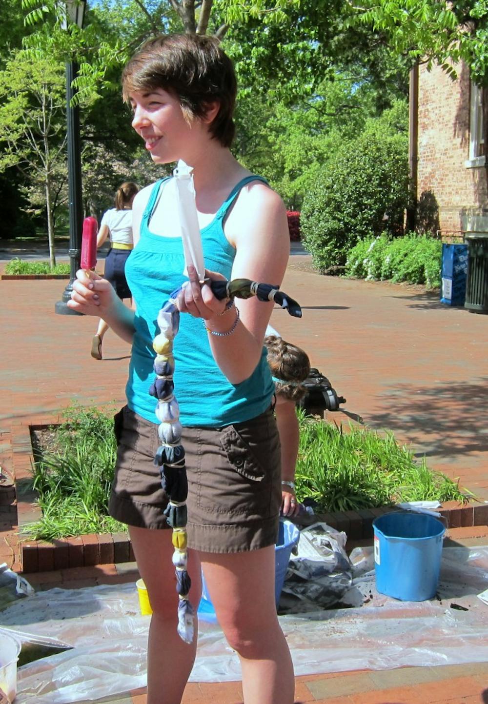 	<p>A Campus Y member enjoys a popsicle while waiting to finish tie-dying. </p>