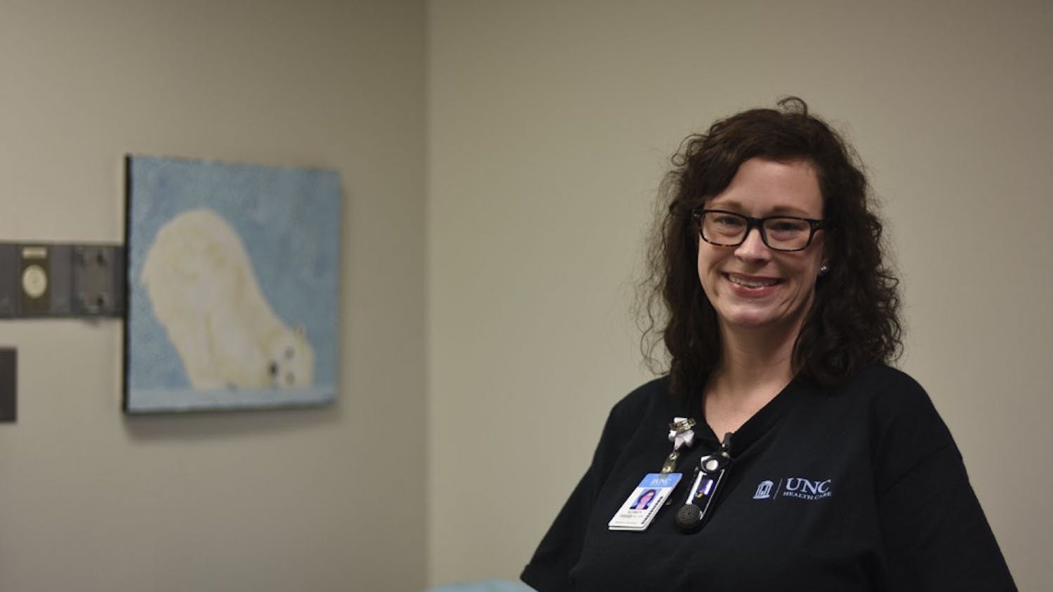 Nurse Koren Garrity in her office in the Behavioral ED near a painting of a polar bear which she displays in order to comfort her patients.
