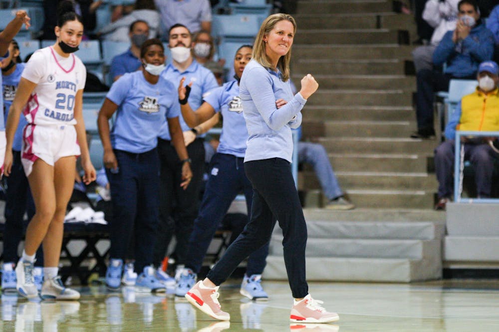 UNC women's head basketball coach Courtney Banghart celebrates at the beginning of a timeout at the game against Miami on Feb. 6, 2022 in Carmichael Arena. The Heels won 85-38.