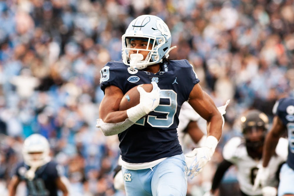 Graduate student running back Ty Chandler (19) runs the ball for a 50-yard touchdown at the game against Wake Forest on Saturday, Nov. 6, 2021 at Kenan Stadium. The UNC Tar Heels won 58-55.