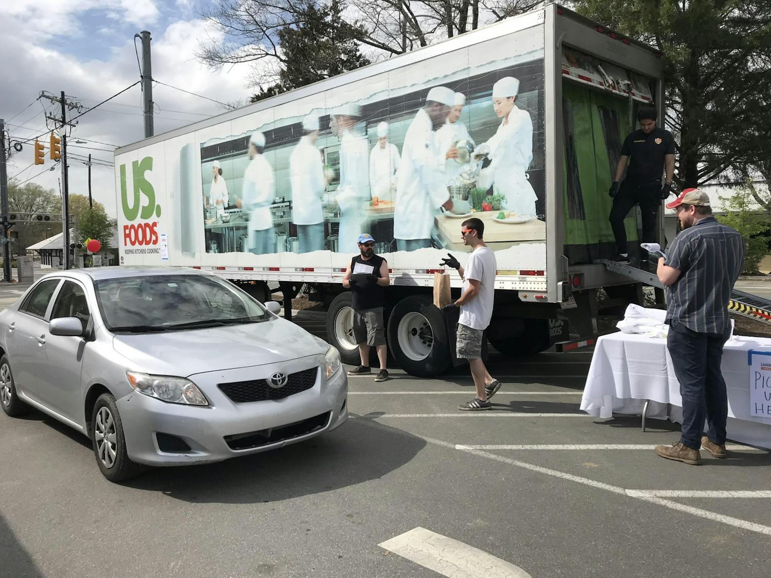 Carrboro United staff, who are all displaced service industry workers, safely deliver food directly to customers' cars on Hub Day at 300 E Main St. in the heart of downtown Carrboro. Photo courtesy of Zoë Dehmer.