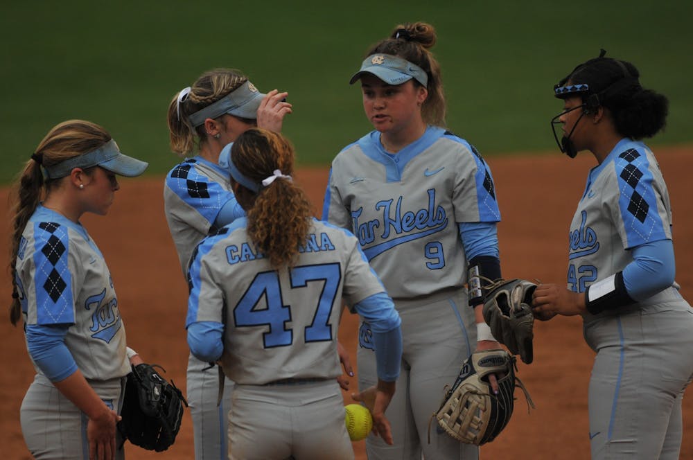(From left) UNC sophomore short-stop Abby Settlemyre (29) , first-year third baseman Destiny Middleton (47), senior second baseman Campbell Hutcherson (5) and sophomore first baseman Lexi Godwin (9) congratulate George sophomore pitcher Hannah George (42) for striking out Elon's hitter during a game against Elon on Wednesday, Feb. 26, 2020 in G. Anderson Softball Stadium. UNC lost to Elon 2-1.