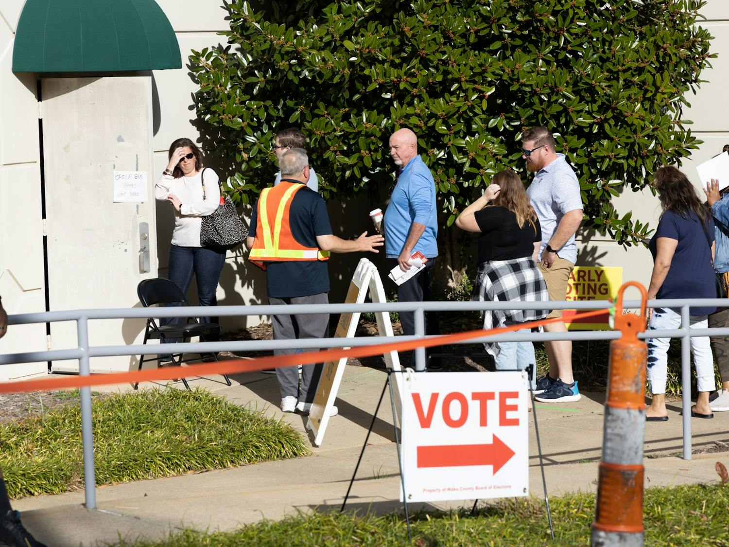 Multiple vested election officials patrol and control the crowds at the Herbert C. Young Community Center voting site on November 3rd, 2022.