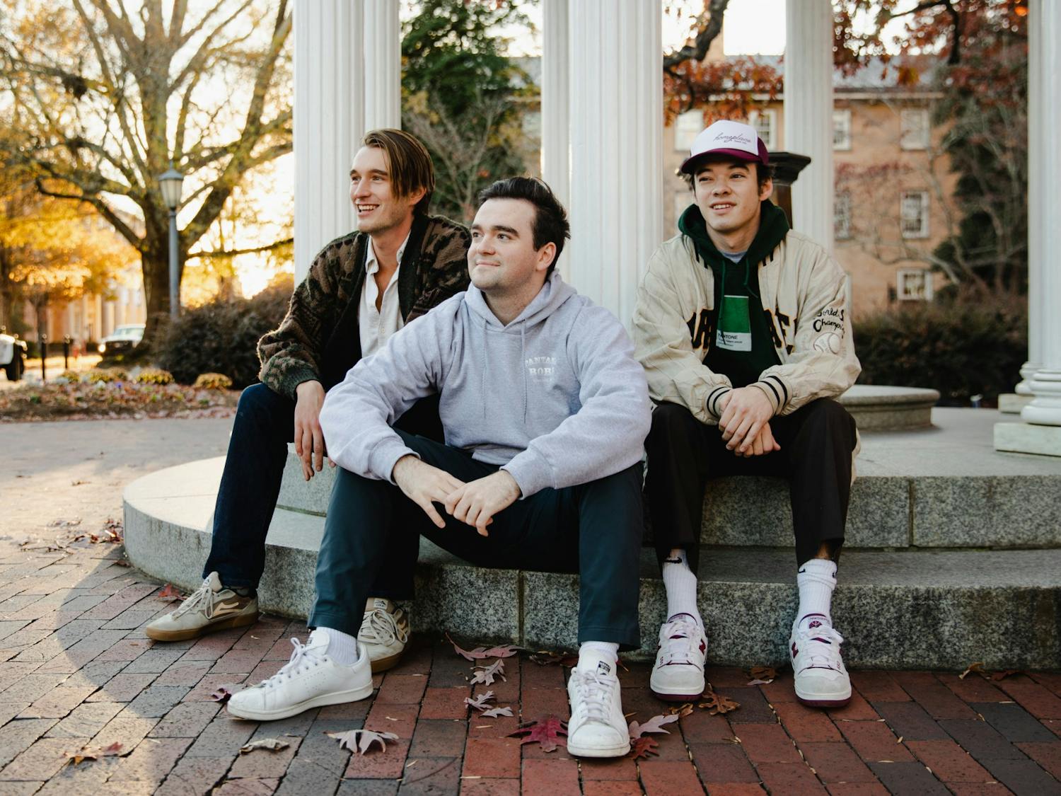 Dylan Melisaratos (middle), a senior Business Administration major, poses for a portrait with his friends James Toole and Matthew Sullivan at the Old Well on Monday, Nov. 29, 2021.