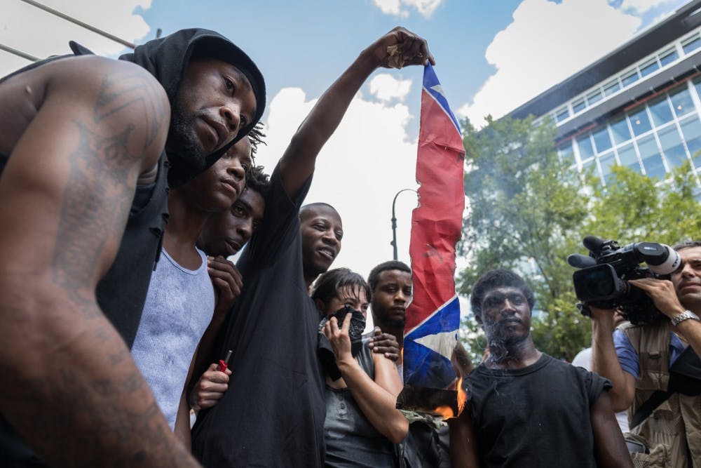 Counter-protestors burn a Confederate flag in anticipation of a KKK rally in Durham.