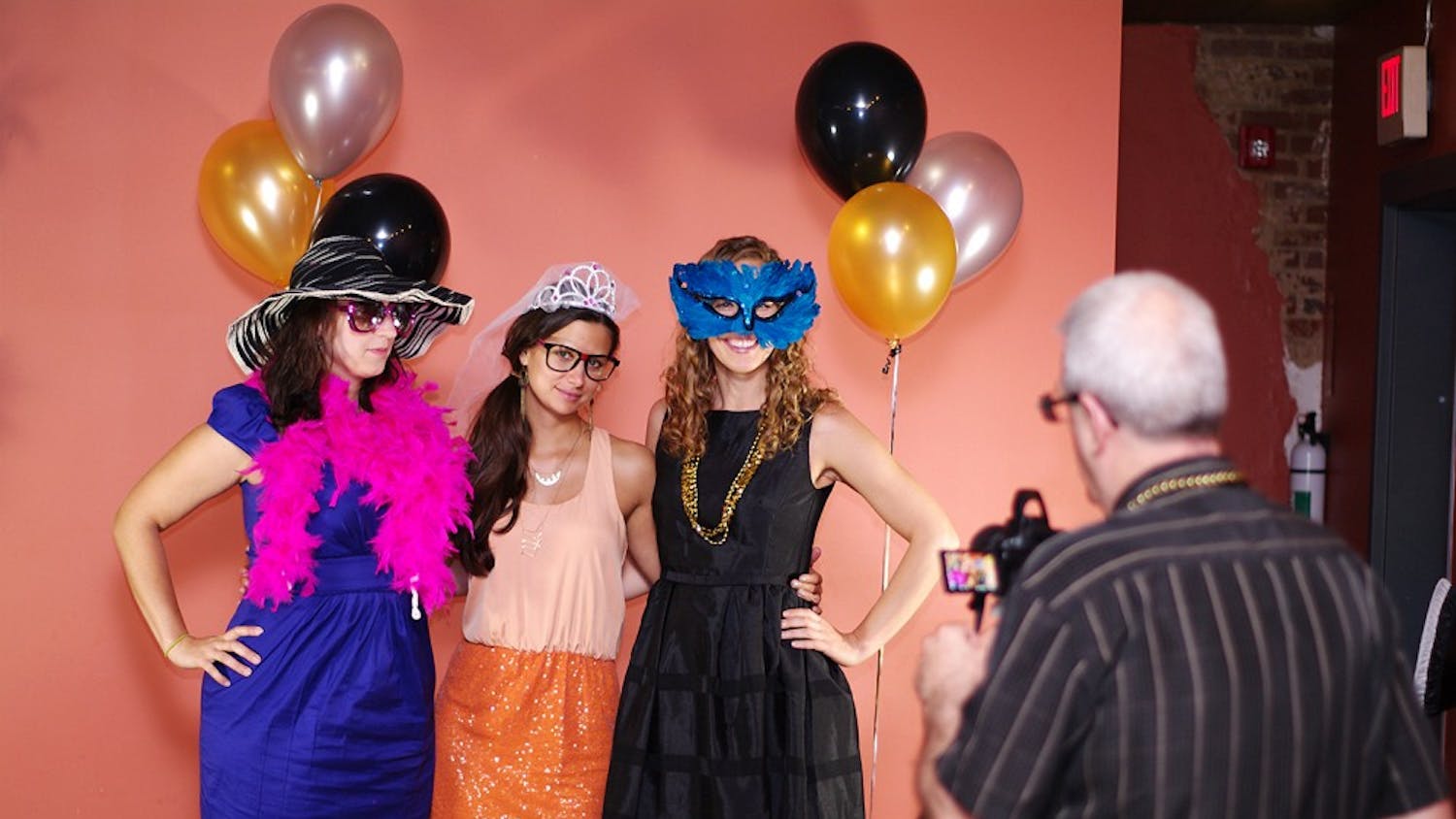 From left to right, Laura Houston, a UNC grad student from Long Island, NY, Claire Dennis, a therapist from Durham, and Colie Taico, the hostess of the event, from Chapel Hill, dress up for the photo booth at 2nd Chance Prom at Looking Glass Cafe on Saturday. 
