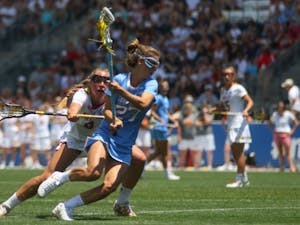 UNC attacker Aly Messinger (27) cradles the ball away from a Maryland defender. Messinger was named the NCAA Tournament's most outstanding player.&nbsp;The North Carolina women's lacrosse team defeated Maryland 13-7 to capture the NCAA championship on Sunday at Talen Energy Stadium in Chester, PA.