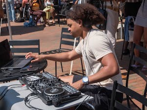 Sophomore DJ Chris Williams plays music in the Pit for "Pit Poppin Fridays," a gathering of Black students on the sunny Friday morning of March 24, 2023.