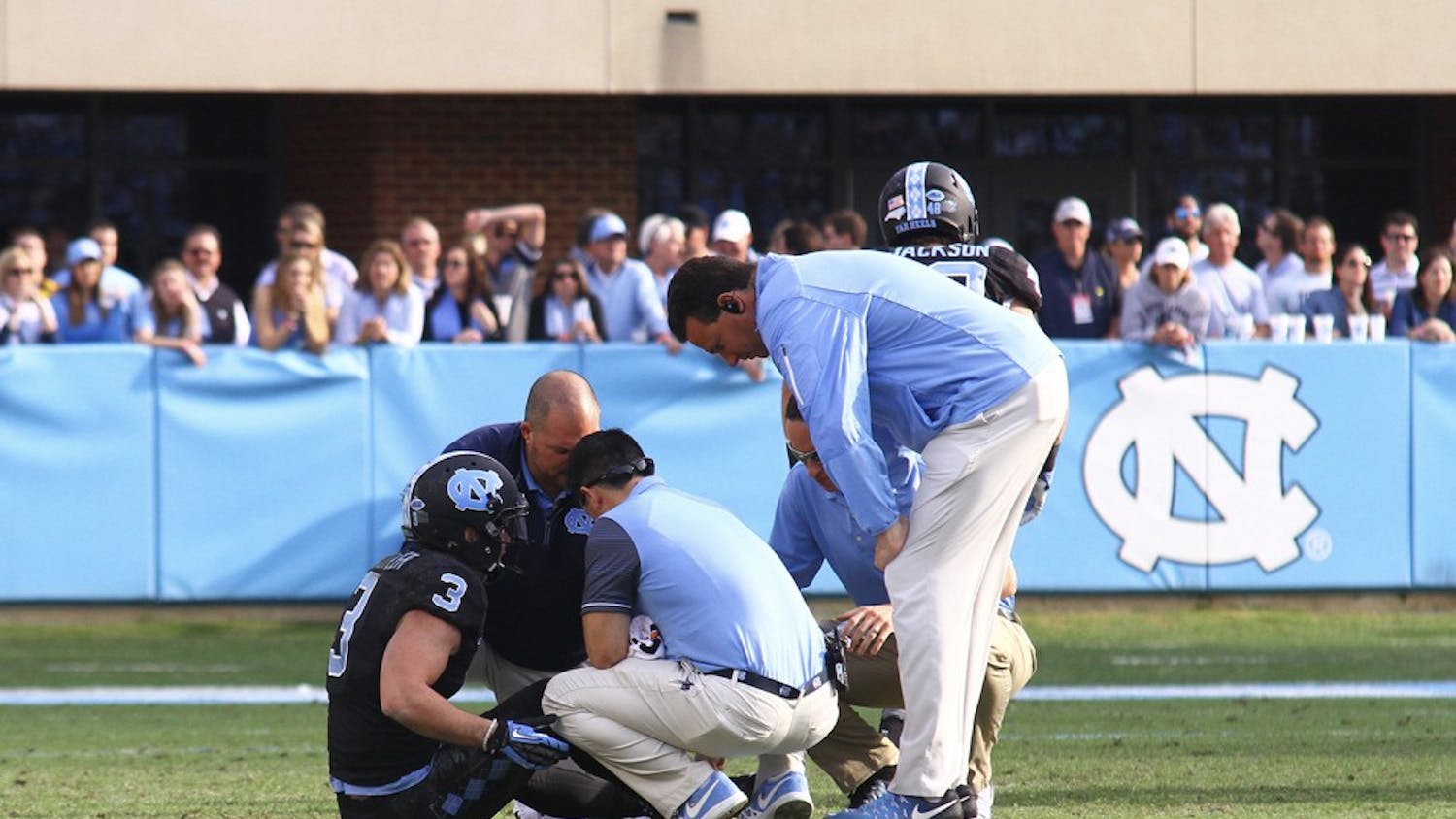 Senior Ryan Switzer (3) is looked at on the field after a minor injury in the game Friday against N.C. State.&nbsp;