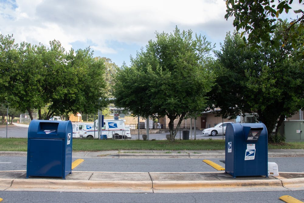 Two USPS collection boxes sit in front of a USPS mail truck parking lot on Sept. 26, 2020 in Matthews, NC.