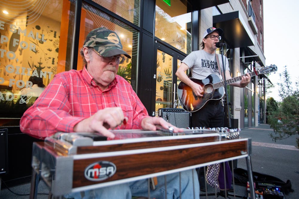 <p>Musicians Clark Albert Blomquist and Steven Watson perform outside Roots Natural Kitchen on Franklin Street in Chapel Hill, North Carolina, on Saturday, April 1, 2023. The performance was part of the Downtown Live series, which features local musicians in outdoor settings in downtown Chapel Hill.</p>