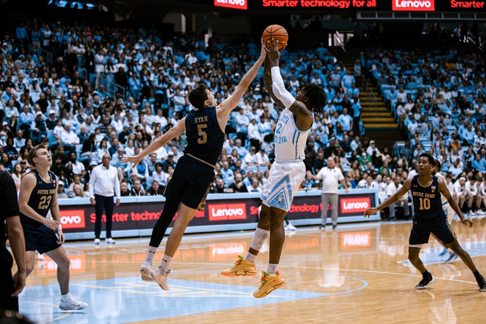 Notre Dame's Cormac Ryan (5) blocks a shot by UNC junior Caleb Love (2) during the men's basketball game against Notre Dame on Saturday, Jan. 7, 2023. UNC won 81-64 at the Smith Center.