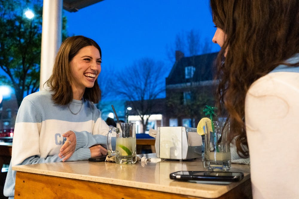 Sophomore public policy major Annabelle Fisher celebrates with her friends at SupDogs after the Tar Heels conquer Saint Peter's in an Elite Eight matchup on Sunday, March 27, 2022.