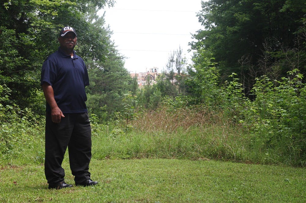 	Reverend Robert Campbell, a concerned Rogers Road resident, stands on neighborhood property just beyond the Orange County landfill’s edge.