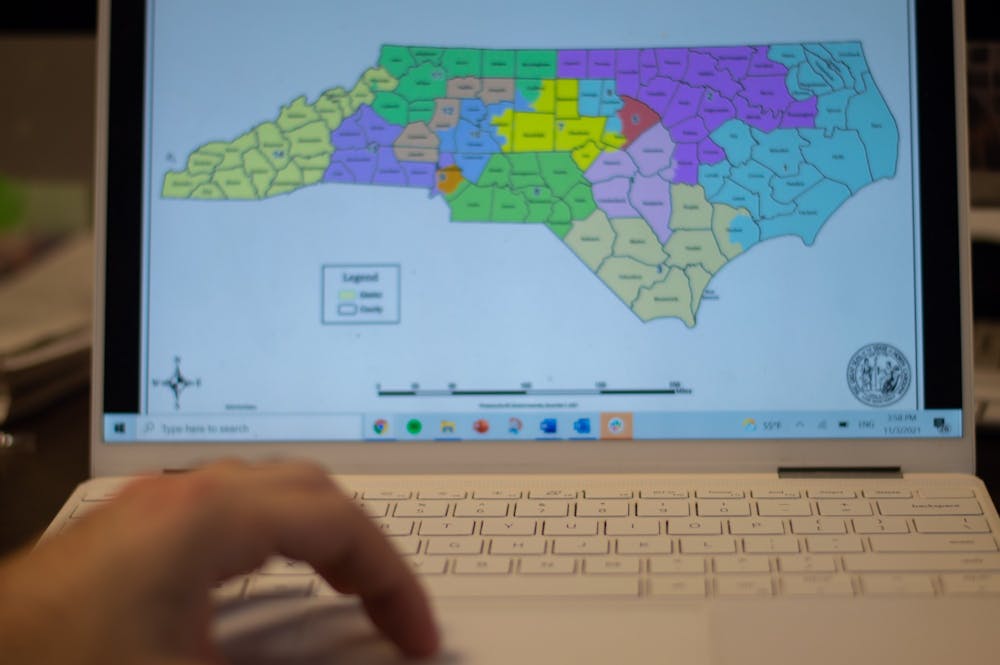 DTH Photo Illustration. A person views the new NC Congressional map.