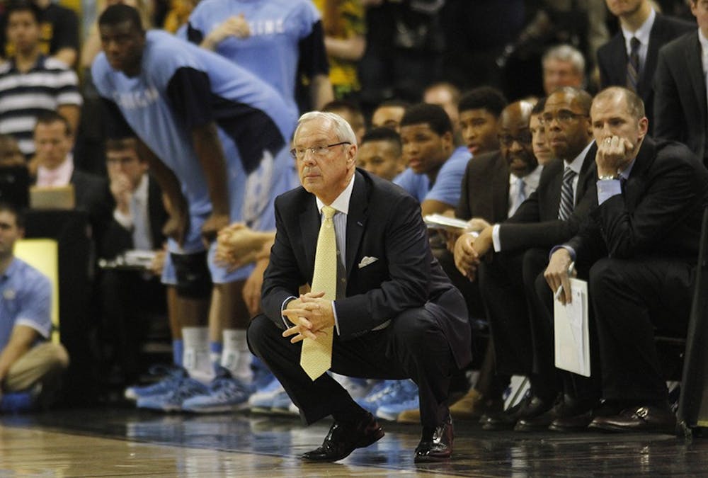 	Coach Roy Williams crouches on the sideline during the game at Wake Forest on Jan. 5.